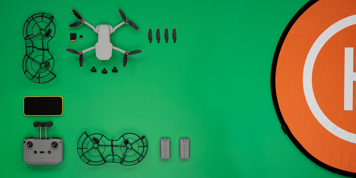 Top view of green background desk table with some drone accessories.