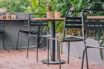 Cozy veranda balcony terrace open air tropical style cafe metal chair table furniture. Green nature leaves summer day. Modern decor interior warm atmosphere Relax Outdoor recreation dining garden area