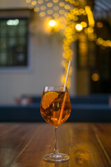 Aperol spritz summer cocktail in mister glass with lime, eco friendly straw and bubbles. Close up. High quality photo