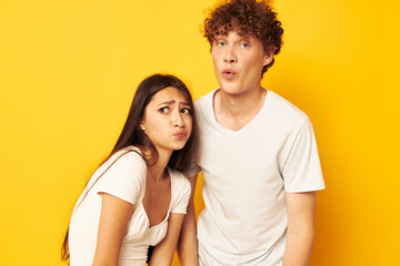 Fototapeta premium cute young couple standing side by side in white t-shirts posing Lifestyle unaltered
