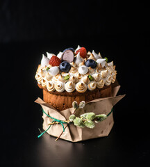 Easter cake on a dark background with a marshmallow, raspberries and blueberries