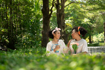 Happy woman talk with friend holding flower in the garden  