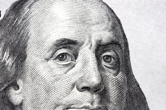 One hundred dollars bill fragment with the portrait of president Benjamin Franklin. Close up of American currency.