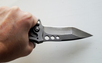 hand holding pliers, knife 