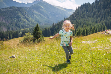 Little girl is relaxing on meadow . Tatra mountains in background. Summer vacation