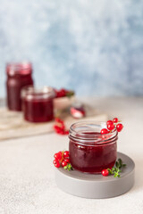 Homemade red currant jam or jelly in glass jars and red currants berries.