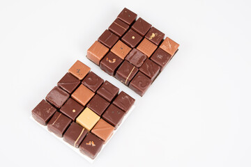 some square chocolate pralines in top view in white background