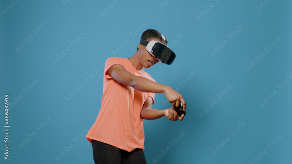 Poster modern woman using vr glasses and controller to play video games in front of camera. carefree person
