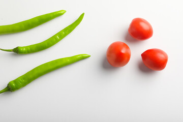 Fresh Green chilli and tomatos on white background.
