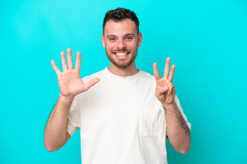 Young Brazilian man isolated on blue background counting eight with fingers