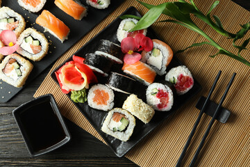 Concept of tasty food with sushi rolls on wooden background