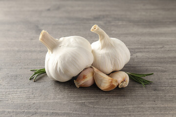 Garlic with rosemary on wooden background, close up