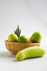 Raw vegetable in wooden bowl on white background.