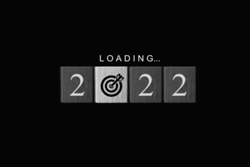 Loading to the 2022 year concept. Word and year numbers on cube blocks with target icon sign