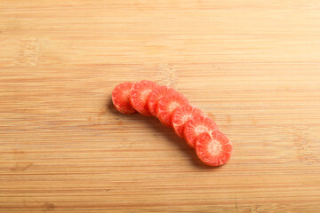 Fresh carrot slices on wooden board.