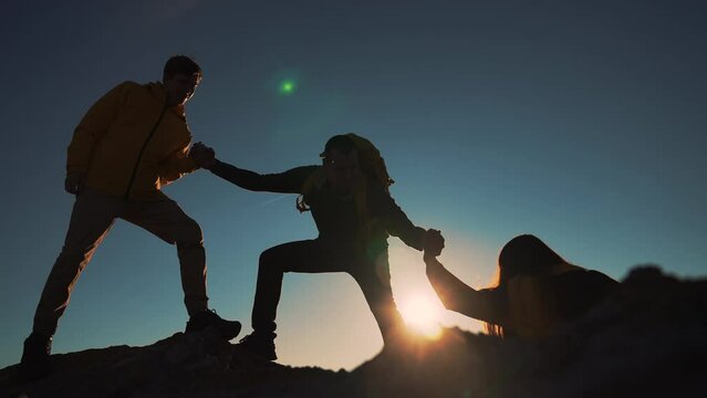 Family team success.Silhouette of group people.Climb to the top of mountain.Helping hand family victory.Teamwork concept.Business handshake.Helping hand of business people.Teamwork is path to success