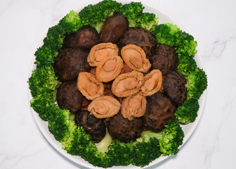 Chinese New Year festive dish. Braised Abalone Mushroom Chicken Feet with Broccoli. Home cooked meals for reunion dinner.