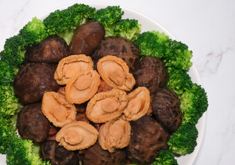 Chinese New Year festive dish. Braised Abalone Mushroom Chicken Feet with Broccoli. Home cooked meals for reunion dinner.