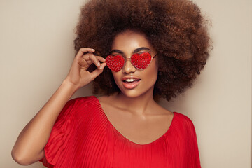 Beautiful portrait of an African girl in sunglasses in the shape of hearts. Valentine's Day. Symbol...