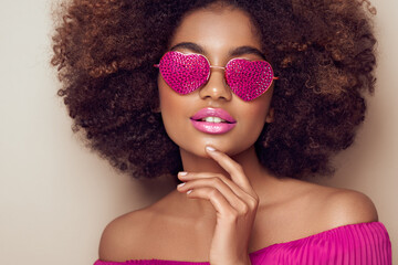 Beautiful portrait of an African girl in sunglasses in the shape of hearts. Valentine's Day. Symbol...