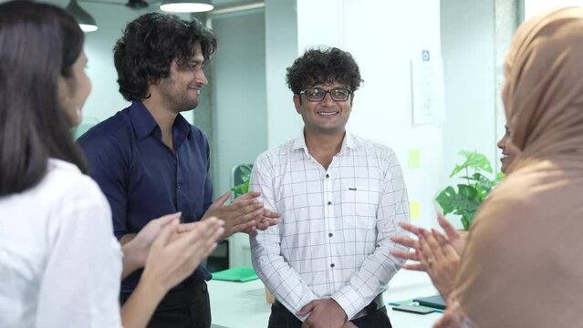 Young Indian boss and colleagues office team applaud support successful proud best male business leader employee get promotion reward professional recognition praising for good work give feedback.