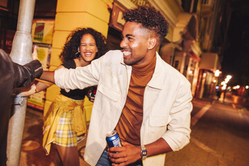 Joyful friends playing around a pole at night © Jacob Lund