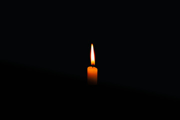 Fototapeta premium glowing candle on the black background