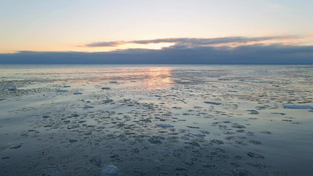 Pieces of ice icebergs floting on Lake Superior, winter sunrise