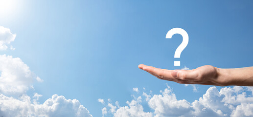 Male hand holding question mark icon on blue background.Banner with copy space. Place for text.