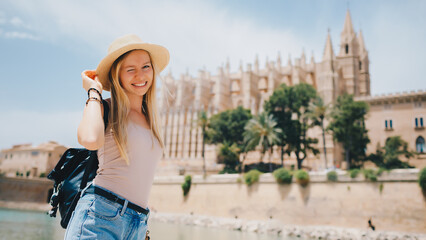 Fototapeta premium Young attractive smiling girl tourist exploring new city at summer