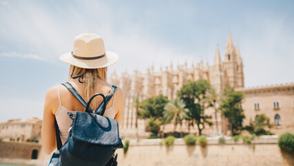 Young attractive smiling girl tourist exploring new city at summer