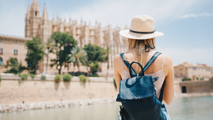 Fototapeta premium Young attractive smiling girl tourist exploring new city at summer