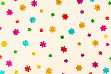 Fototapeta na wymiar Creative layout made of colorful flower sequins on bright background. Minimal spring or summer aesthetic. Valentines day or Mothers day concept. Top view, flat lay.