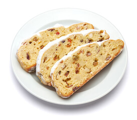 Slices of Traditional Christmas stollen cake with marzipan and dried fruit isolated on white ceramic palte