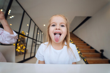 Little girl sticking out tongue at camera close-up © teksomolika