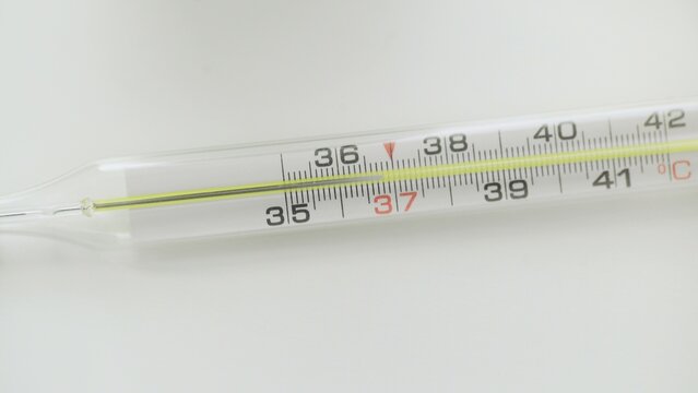 A close-up of a glass mercury thermometer shows a low temperature