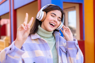 Young Brazilian woman at outdoors listening music and singing