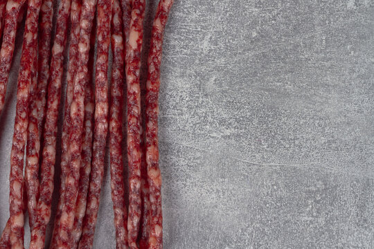Smoked sausages for beer are thin and long on a gray background. Copy Space
