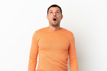 Brazilian man over isolated white background looking up and with surprised expression
