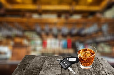 Glass of alcohol whiskey on the bar counter. Blurred interior of bar at the background.