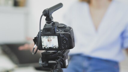 A young woman with glasses turns on the camera, smiles and talks to the camera. Greeting your viewers