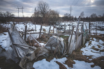 ruins of plastic greenhouse under high voltage electric transmission lines