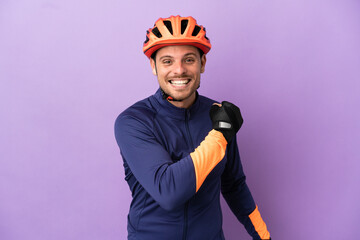 Young Brazilian cyclist man isolated on purple background celebrating a victory