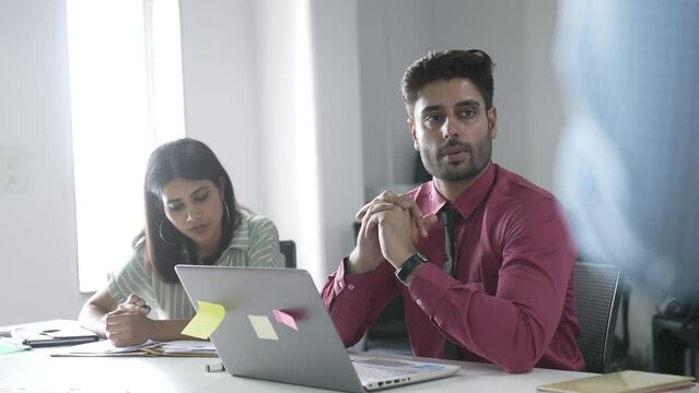 Indian businessman and woman of ethnicity taking an important and critical financial decision in a conference meeting. A serious and focused creative office workers interacting on upcoming project.