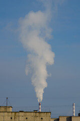 The smoke comes from the chimney of local power station. Heating season in city. Air pollution by...