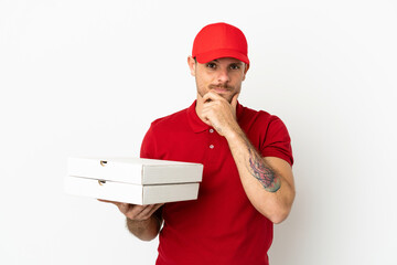 pizza delivery man with work uniform picking up pizza boxes over isolated  white wall thinking