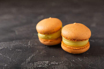 Delicious berry macaroons on a dark marble background. French meringue cookies macaron. Culinary and cooking concept. Copy space. top view.