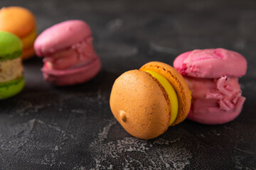 Delicious berry macaroons on a dark marble background. French meringue cookies macaron. Culinary and cooking concept. Copy space. top view.