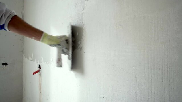 Construction Worker Applying Plaster On A Drywall