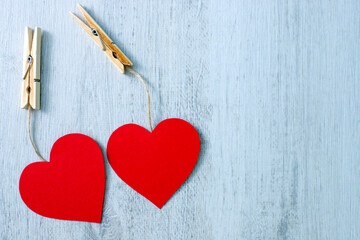 hearts hanging on a clothesline, Valentines day, two hearts on white wooden background, copy space